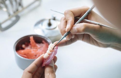 closeup-shot-of-hands-working-on-a-denture-2023-01-26-10-18-25-utc