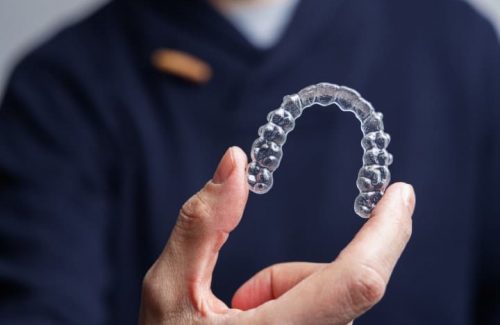 man-holding-one-transparent-aligner-invisalign-or-2023-02-28-18-33-52-utc